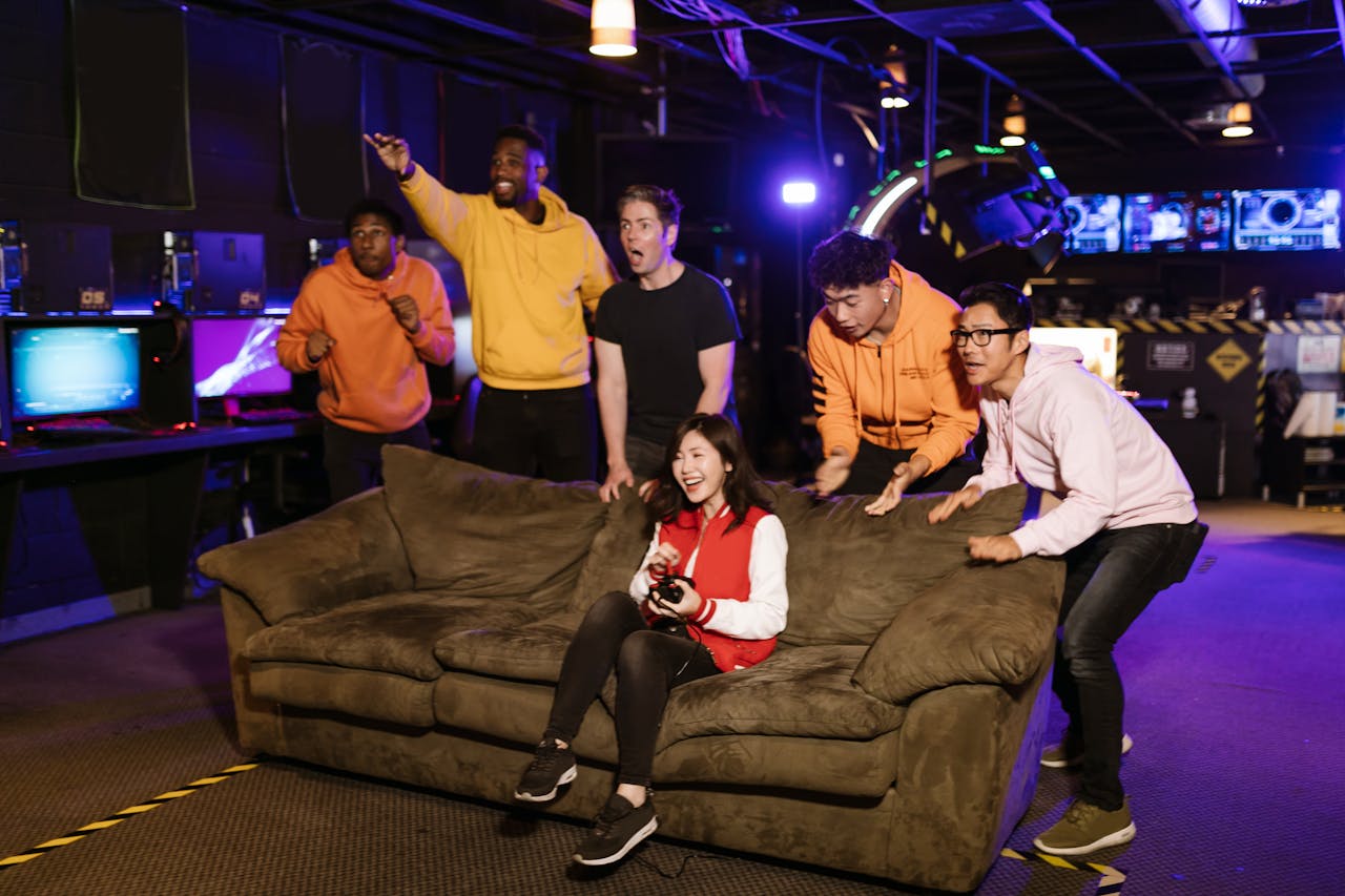 A diverse group of friends gaming indoors, sharing excitement and fun during video game play on a cozy couch.